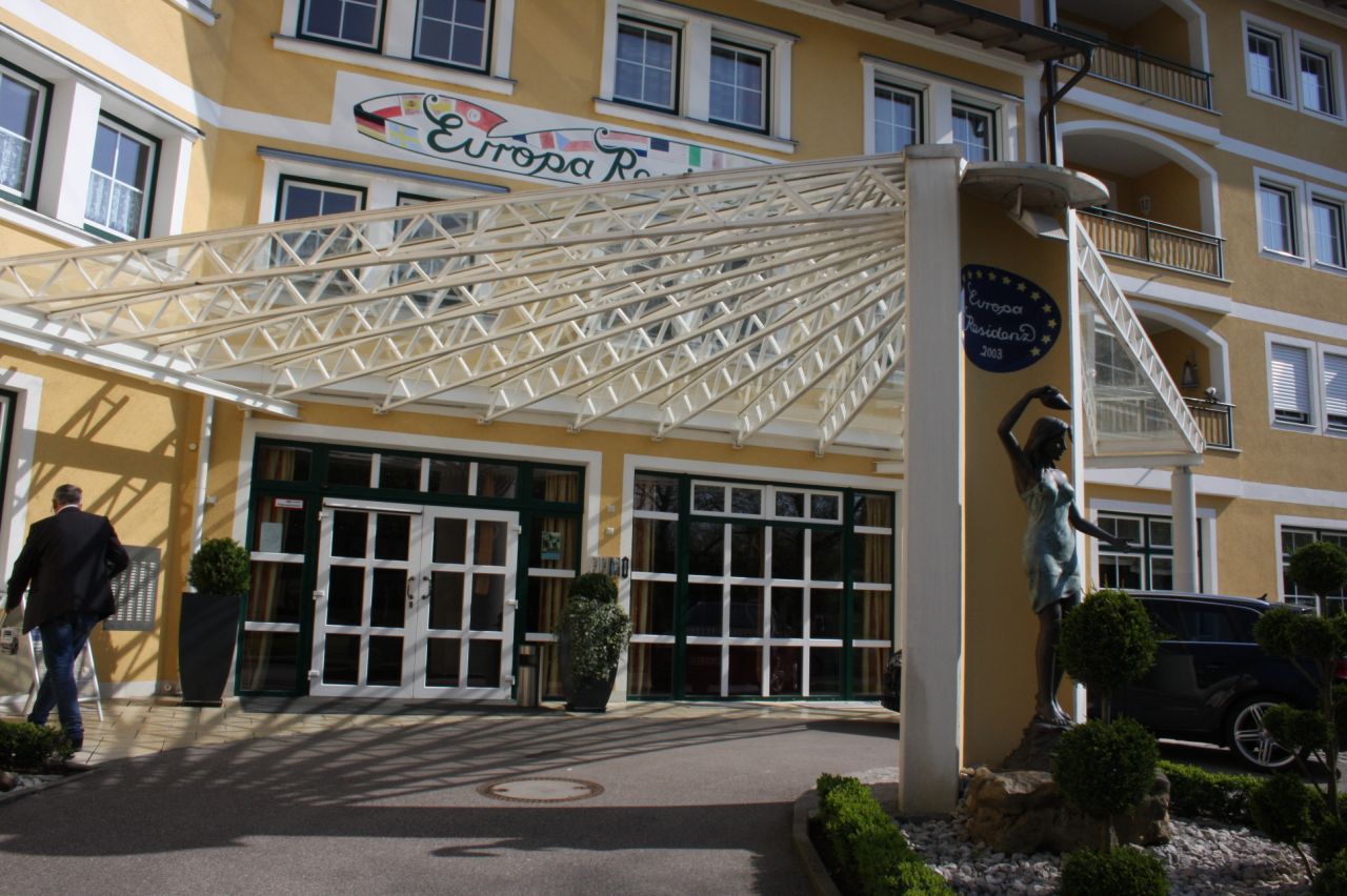 Einladender Eingangsbereich mit moderner Überdachung und stilvoller Skulptur