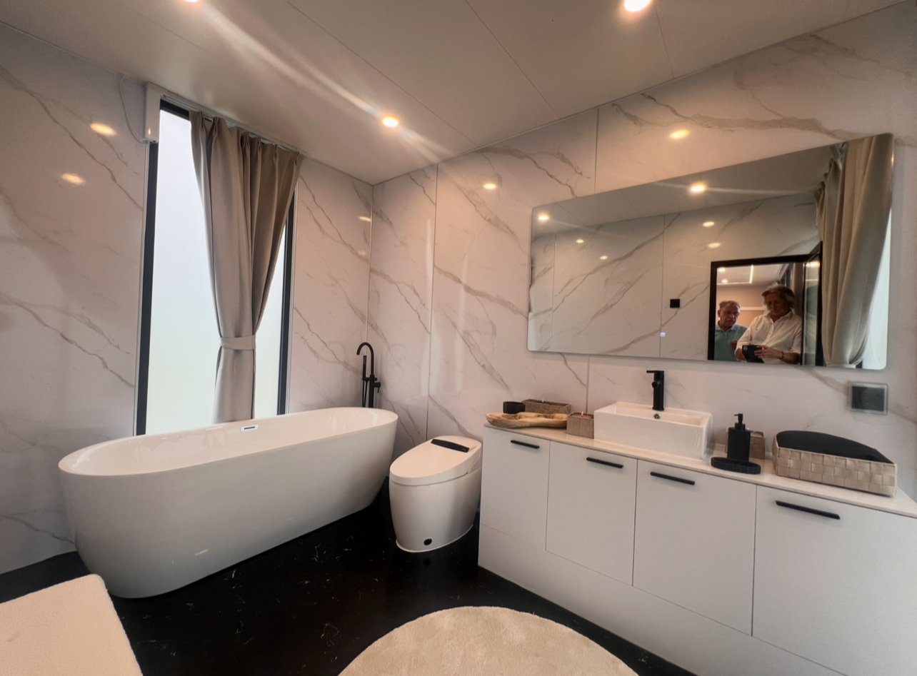 Wellness-Oase mit freistehender Badewanne und luxuriöser Marmor-Wandverkleidung