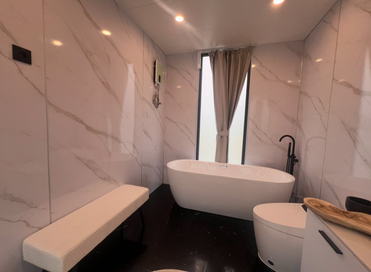 Luxus-Wellness-Oase: Freistehende Badewanne mit elegantem Marmor-Ambiente und natürlichem Lichteinfall