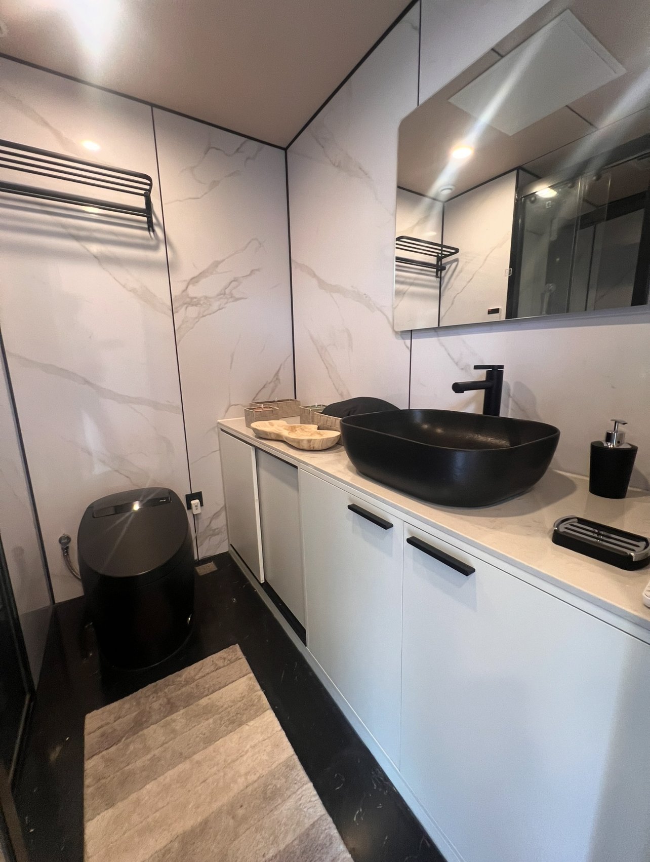 Exklusives Designbad mit edles Marmor-Ambiente und moderner Schwarzakzent-Ausstattung Exklusives Designbad mit edles Marmor-Ambiente und moderner Schwarzakzent-Ausstattung