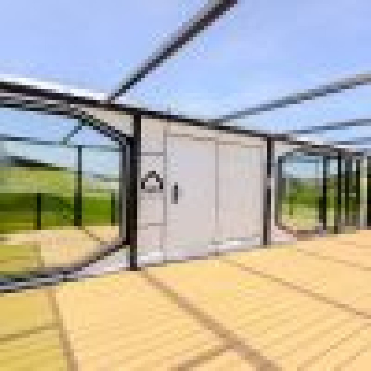 Lichtdurchflutete Gewächshauserweiterung mit panoramischer Landschaftsaussicht Lichtdurchflutete Gewächshauserweiterung mit panoramischer Landschaftsaussicht