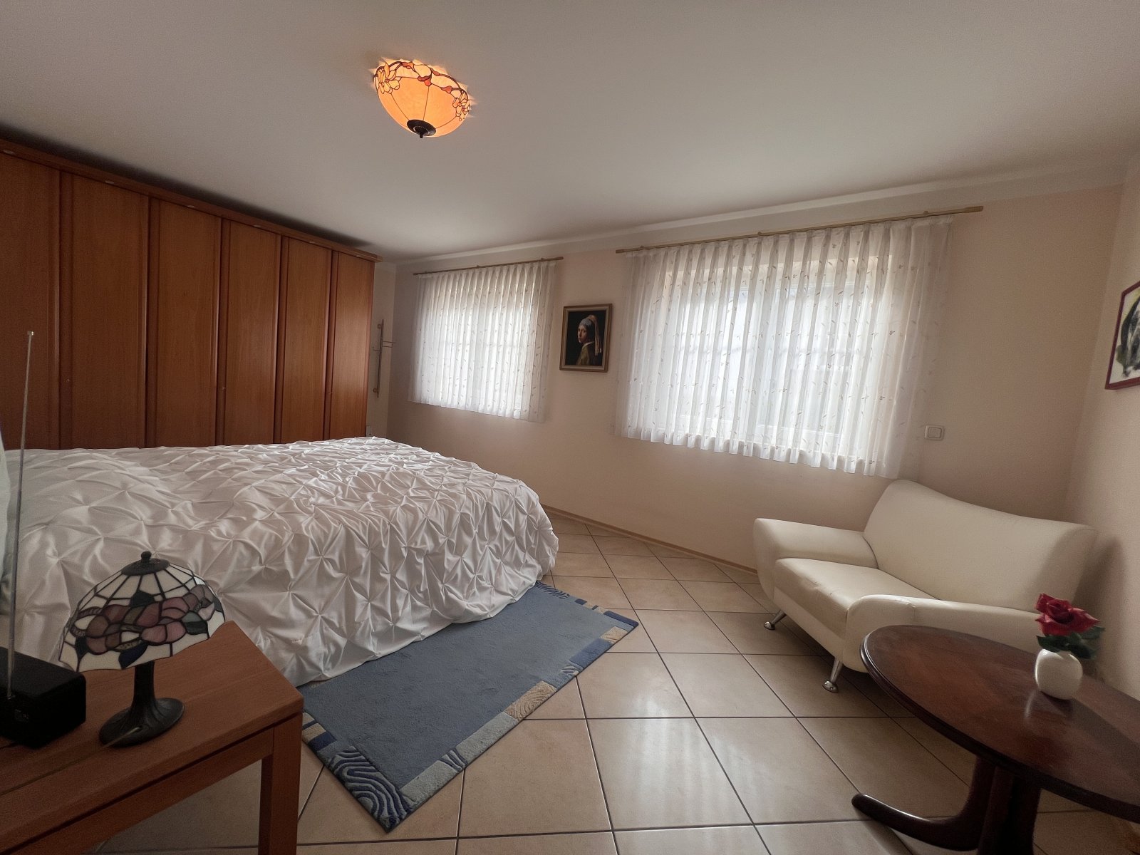 Geräumiges Schlafzimmer mit XXL-Einbauschrank und gemütlicher Sitzecke