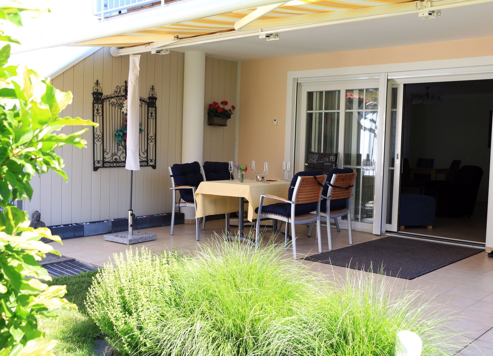 Überdachte Terrasse mit Charme - Einladende Outdoor-Essecke mit Sonnenschutz und elegantem Design