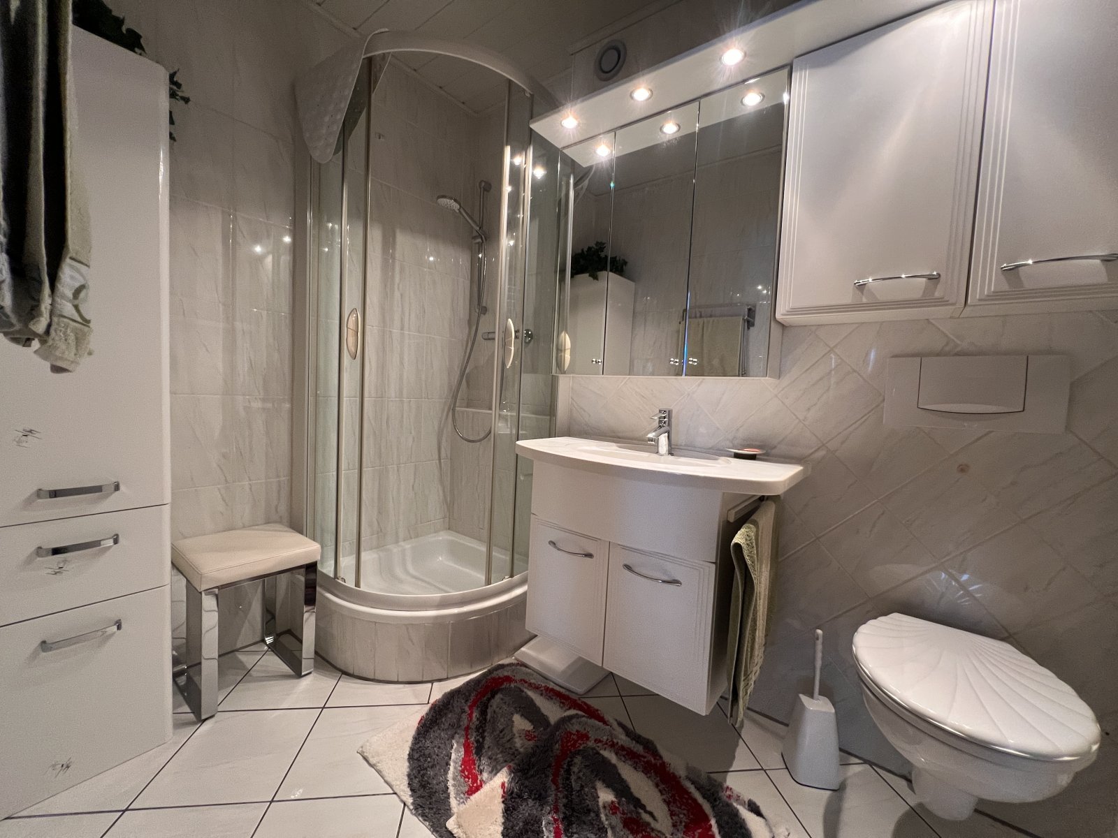 Geräumiges Badezimmer mit moderner Dusche und praktischem Stauraum