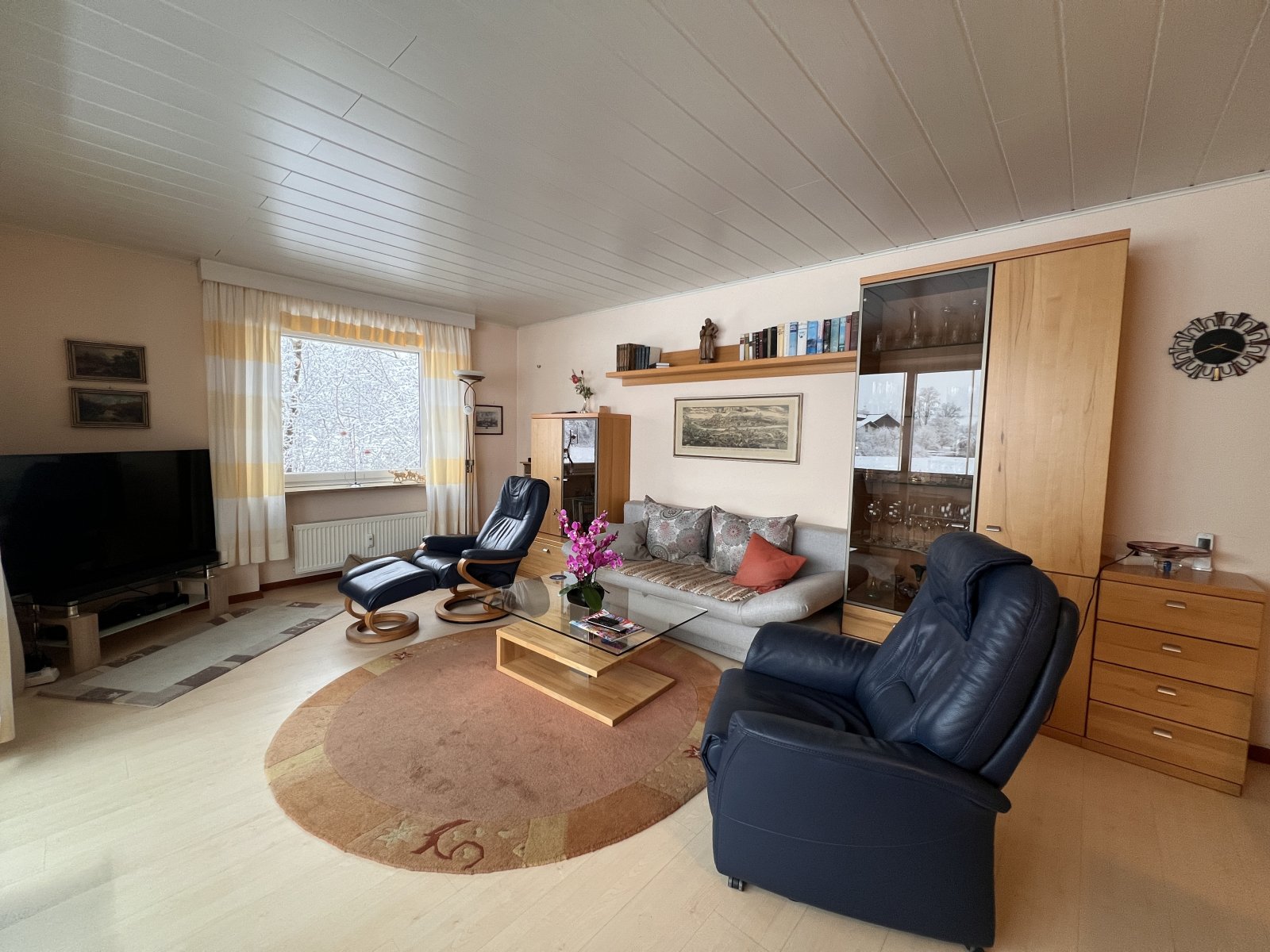 Gemütliches Wohnzimmer mit durchdachter Raumaufteilung und fest verbauten Stauraummöbeln