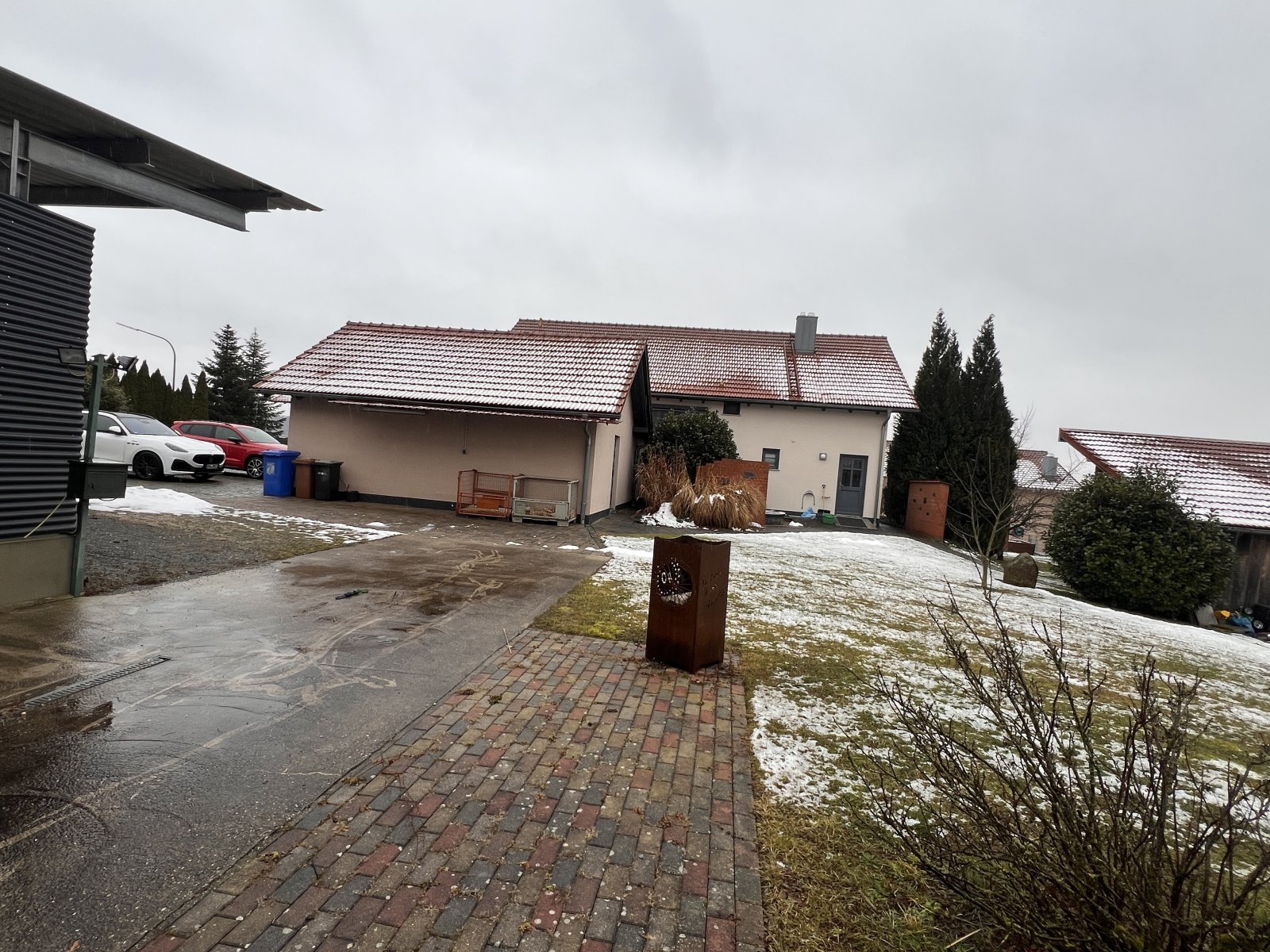 Geräumiger Außenbereich mit Stellplätzen und gepflegtem Gartenanteil