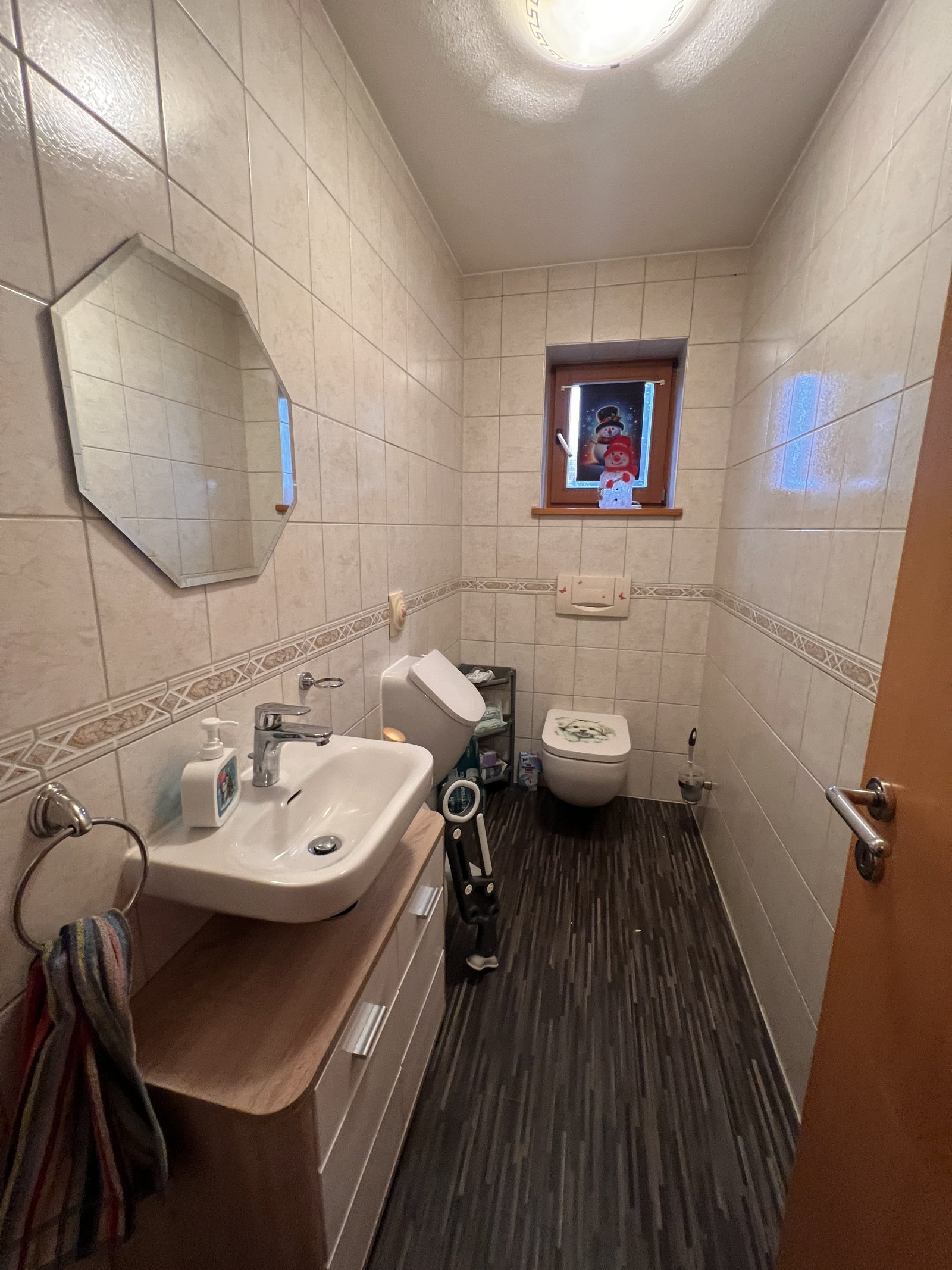 Helles Badezimmer mit praktischem Waschtisch und WC, durchdachte Raumaufteilung