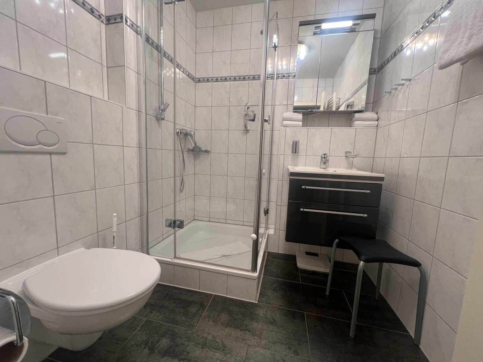 Modernes Badezimmer mit Dusche, WC und praktischem Waschtischunterschrank