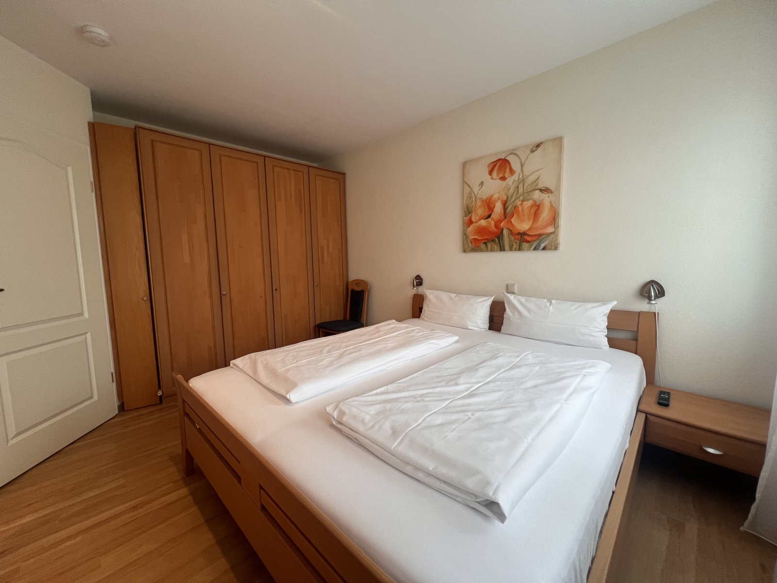 Geräumiges Schlafzimmer mit integriertem Kleiderschrank und moderner Beleuchtung