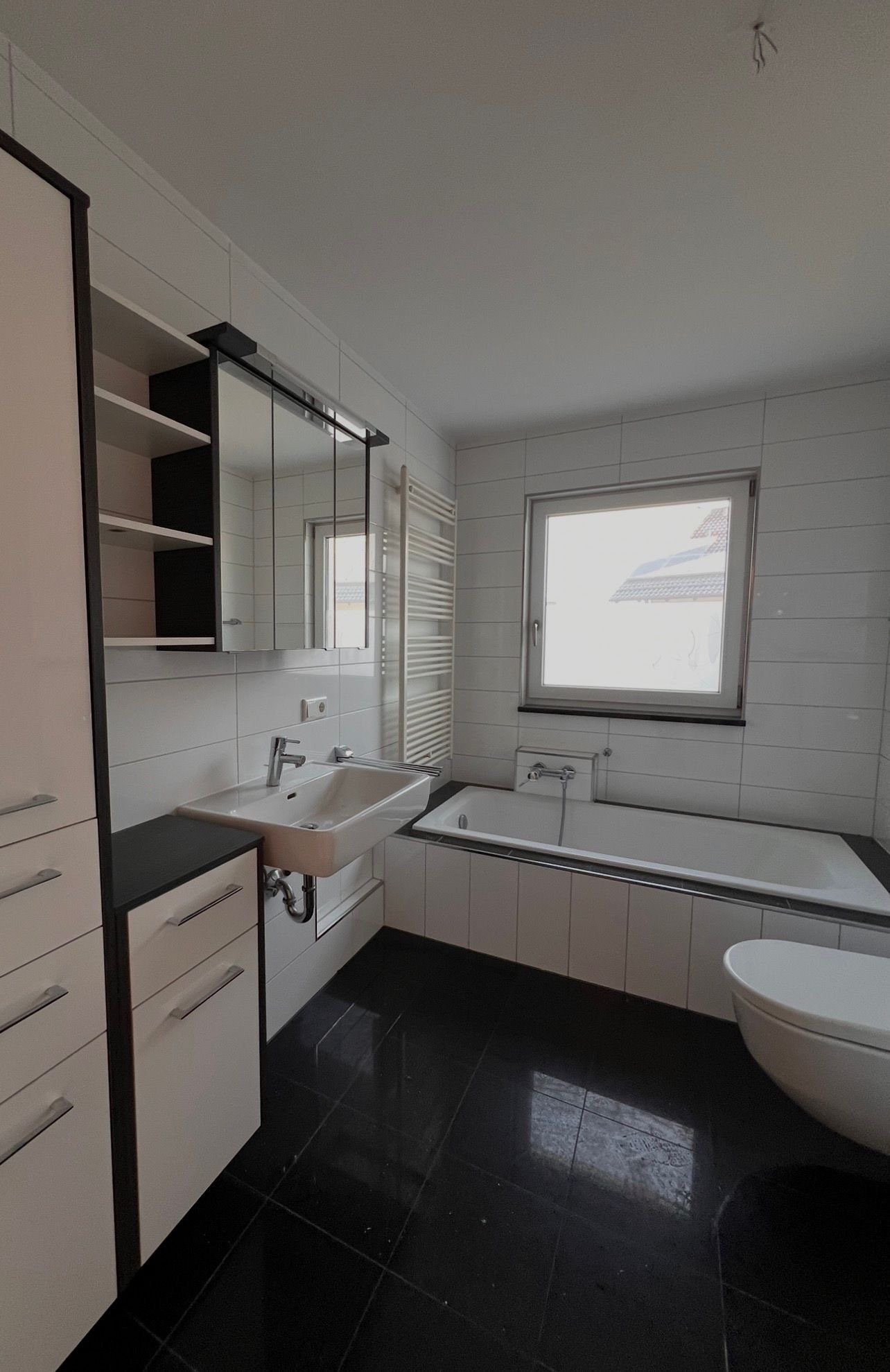 Modernes Badezimmer mit Wanne, Dusche und praktischen Stauraum-Lösungen