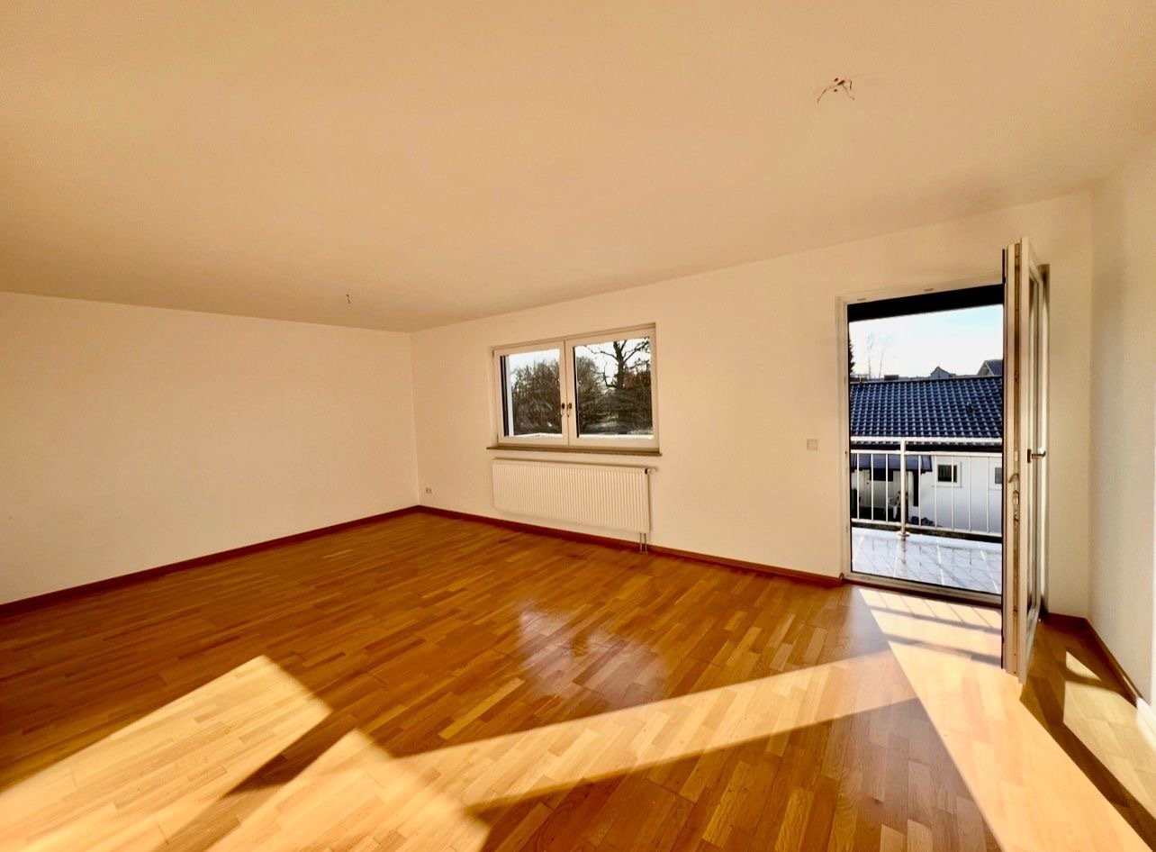 Helles Wohnzimmer mit Balkonzugang und Panoramafenstern