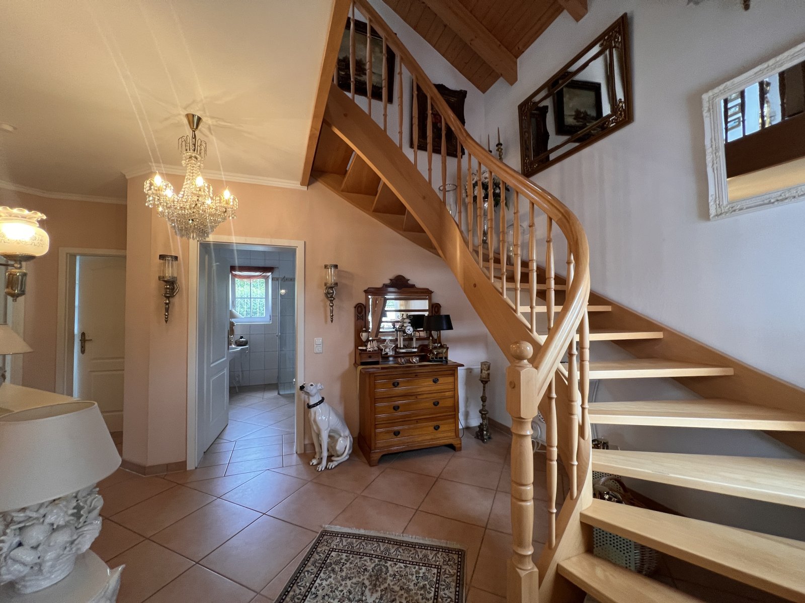 Elegante Eingangshalle mit geschwungener Holztreppe und offener Raumstruktur Elegante Eingangshalle mit geschwungener Holztreppe und offener Raumstruktur