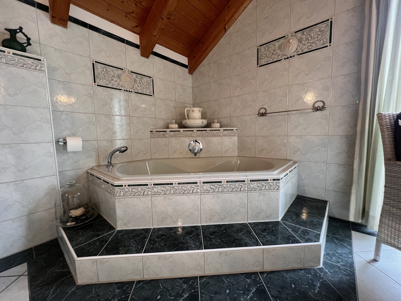 Wellness-Badezimmer mit Eckwanne, Regendusche und Holzbalkendecke Wellness-Badezimmer mit Eckwanne, Regendusche und Holzbalkendecke