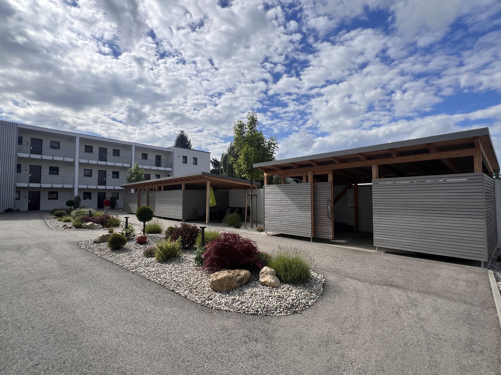 Moderne Außenanlagen mit funktionalem Carport und pflegeleichtem Gartenkonzept Moderne Außenanlagen mit funktionalem Carport und pflegeleichtem Gartenkonzept